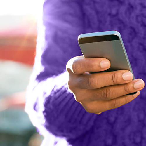 person with purple sweater holding a phone